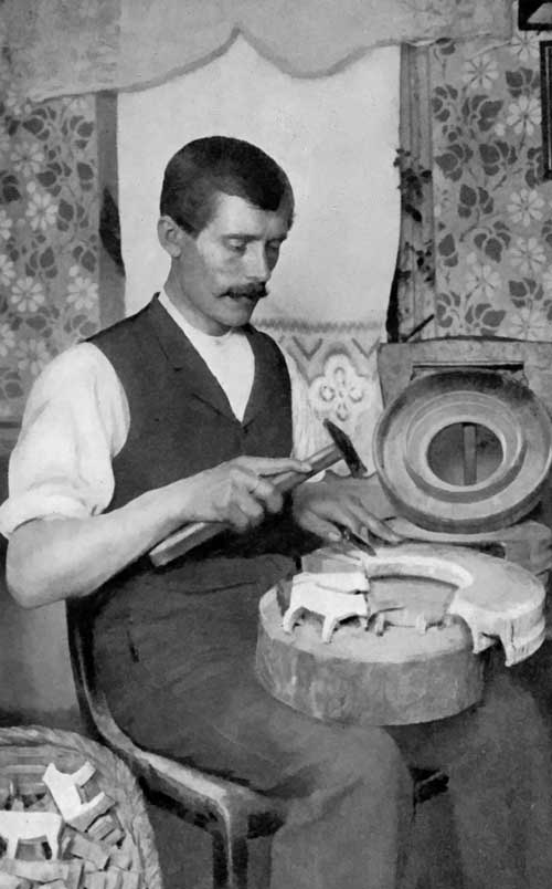 Toy-making in Germany. How the rough figures are chipped from the wooden ring coming from the cross-section of a tree.