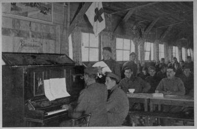 TICKLING THE OLD IVORIES Many an ancient piano did herculean service in the A. R. C. recreation huts throughout France