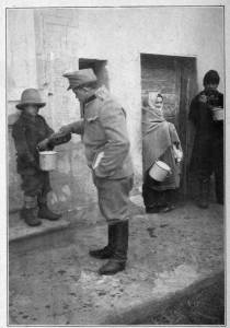 Photograph from Henry Ruschin AUSTRIAN SOLDIER IN CARPATHIANS GIVING HUNGRY YOUNGSTER SOMETHING TO EAT Moved by the misery of the civilian population the soldiers will often share their rations with them. An Austrian soldier in this case shares his food with a boy in a small town in the Carpathian Mountains, Hungary.