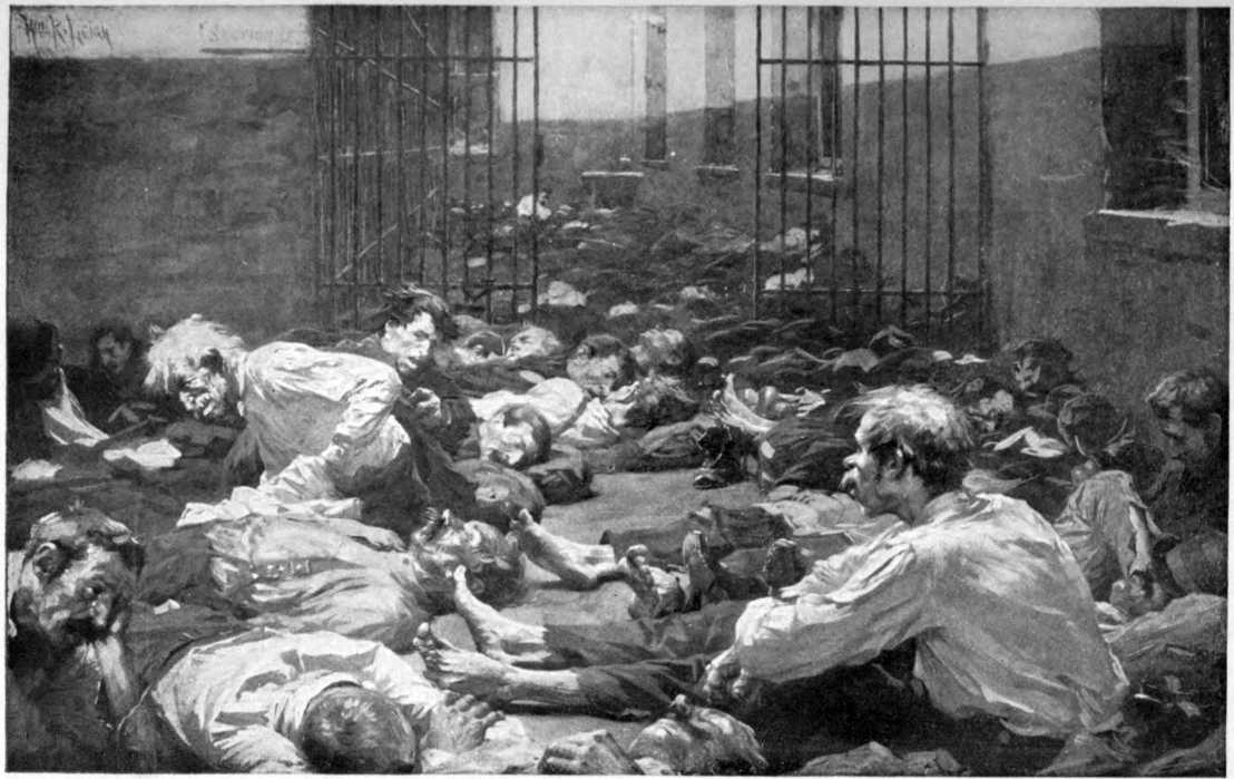 Men, without jackets or shoes, sprawled all over the floor with little open space. The bars of a jail can be seen.