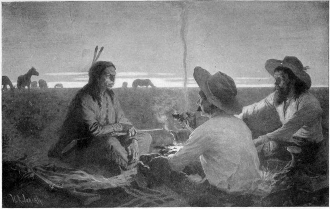 Three men sit on the ground around a campfire with one a Native American. It is near sunset and there are horses in the background.