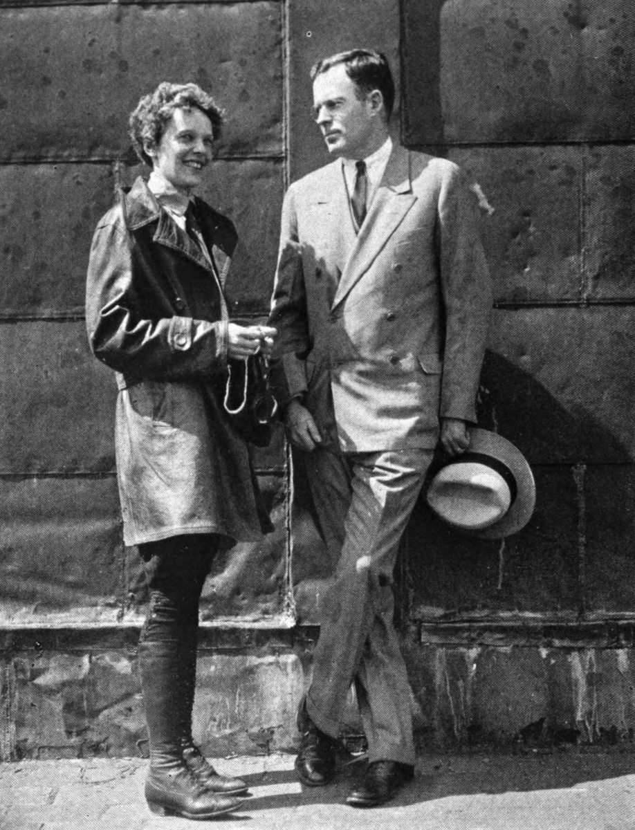 Photo full shot Earhart and Putman standing against block wall