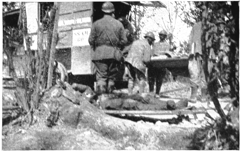 Uniformed men loading individuals on gurneys into a wagon.